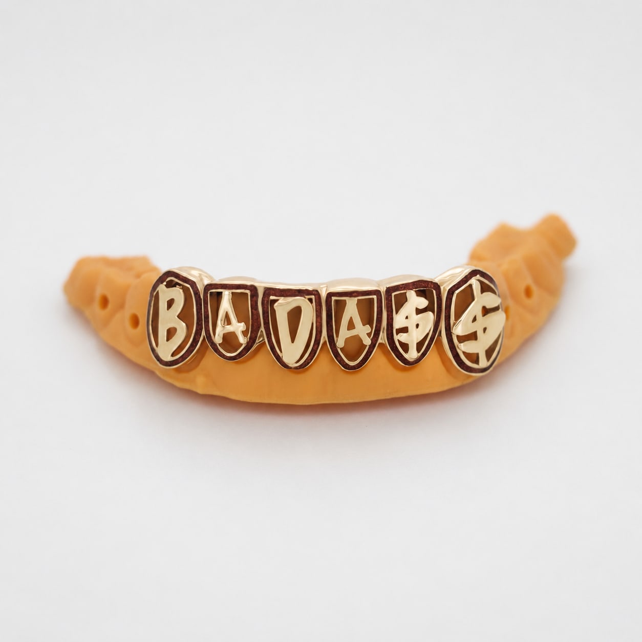 Custom Joey Bada$$ grillz spelling BADASS on a dental model
