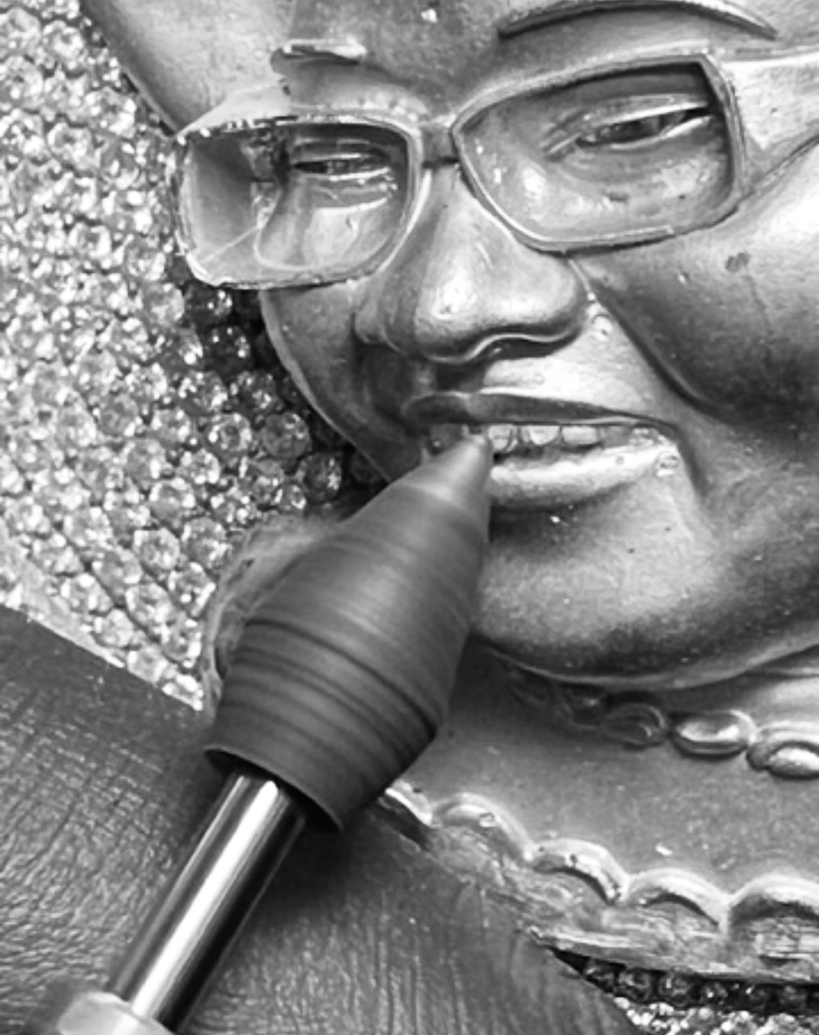 Close-up of a three-dimensional portrait pendant being sculpted by hand